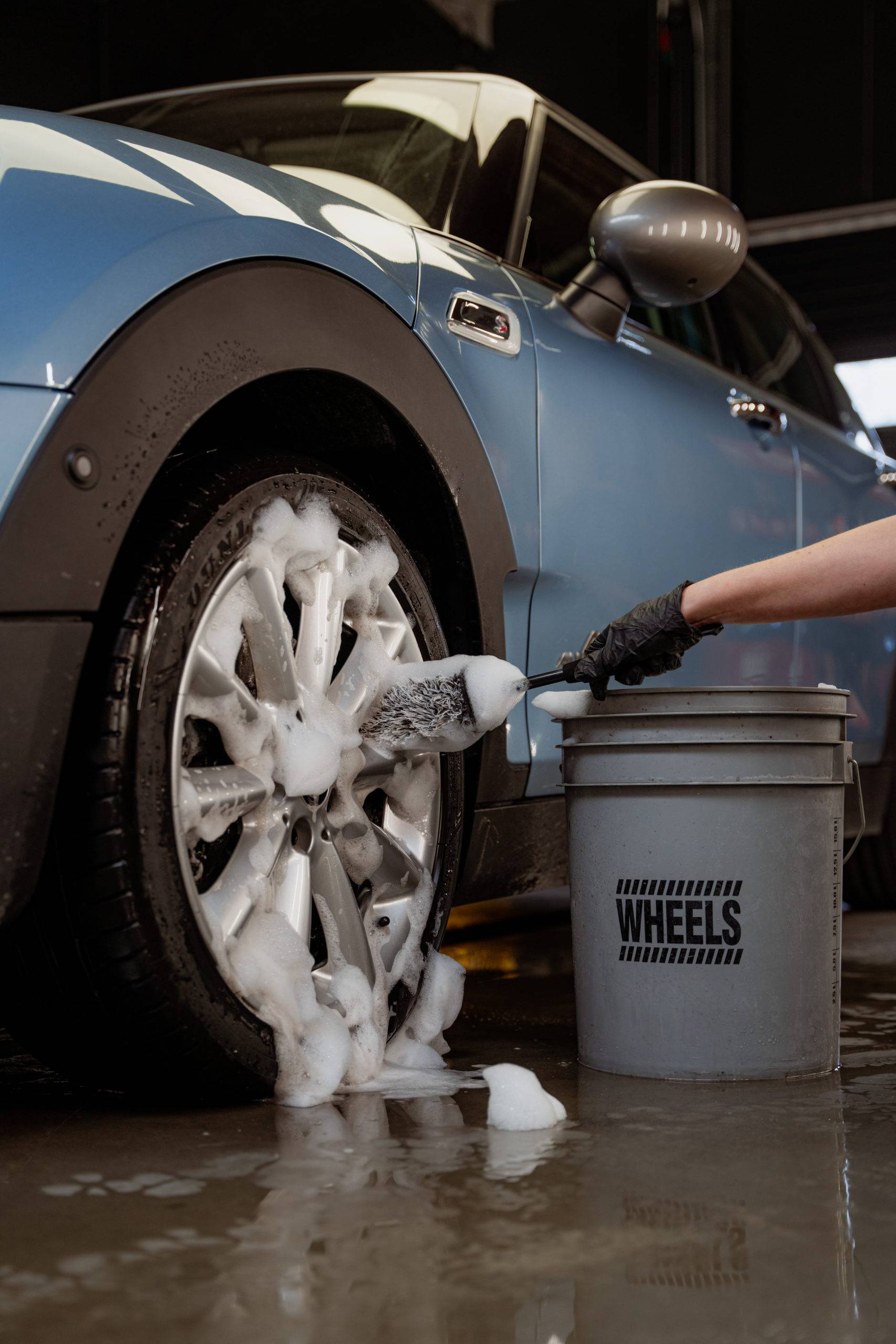 SQUALLY compact microfiber wheel brush cleaning a foamy wheel