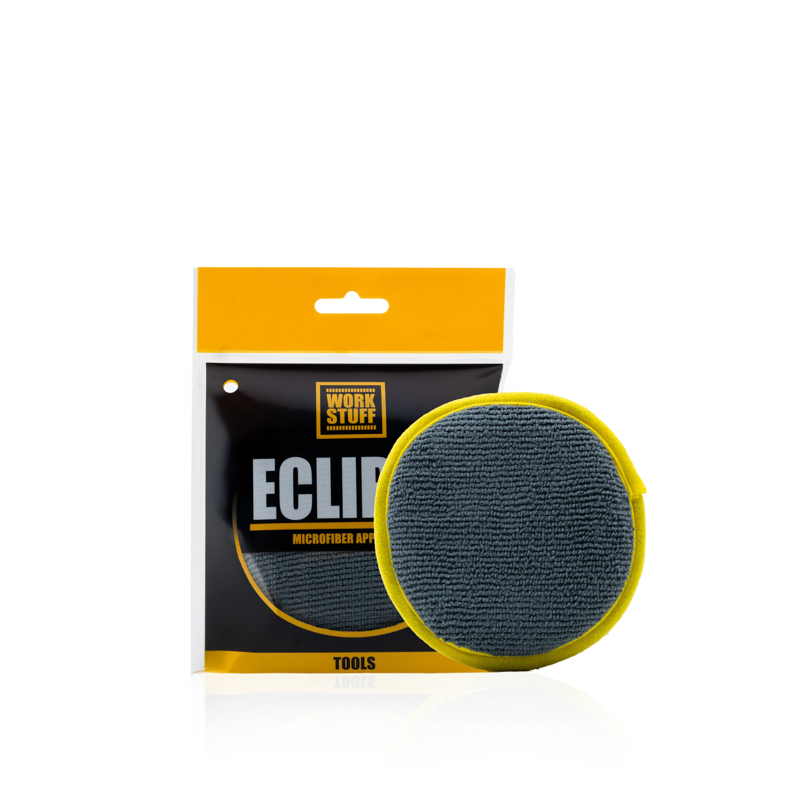 A gray, round microfiber applicator pad with a yellow edge sits before its black and orange Eclipse packaging by Work Stuff.