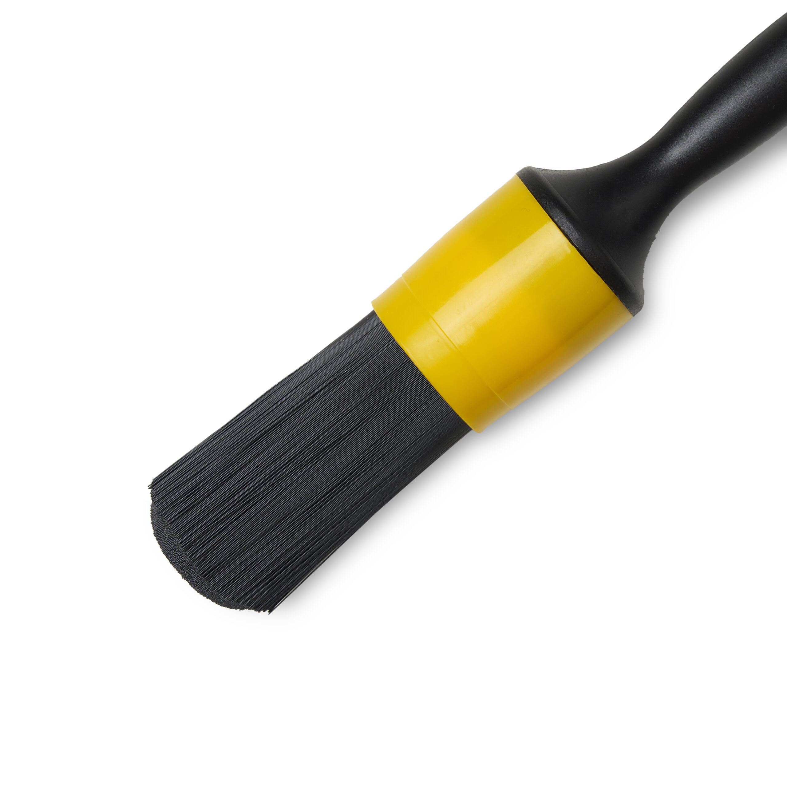 Close-up of a black cleaning brush with stiff synthetic bristles and a yellow handle, isolated on white background.