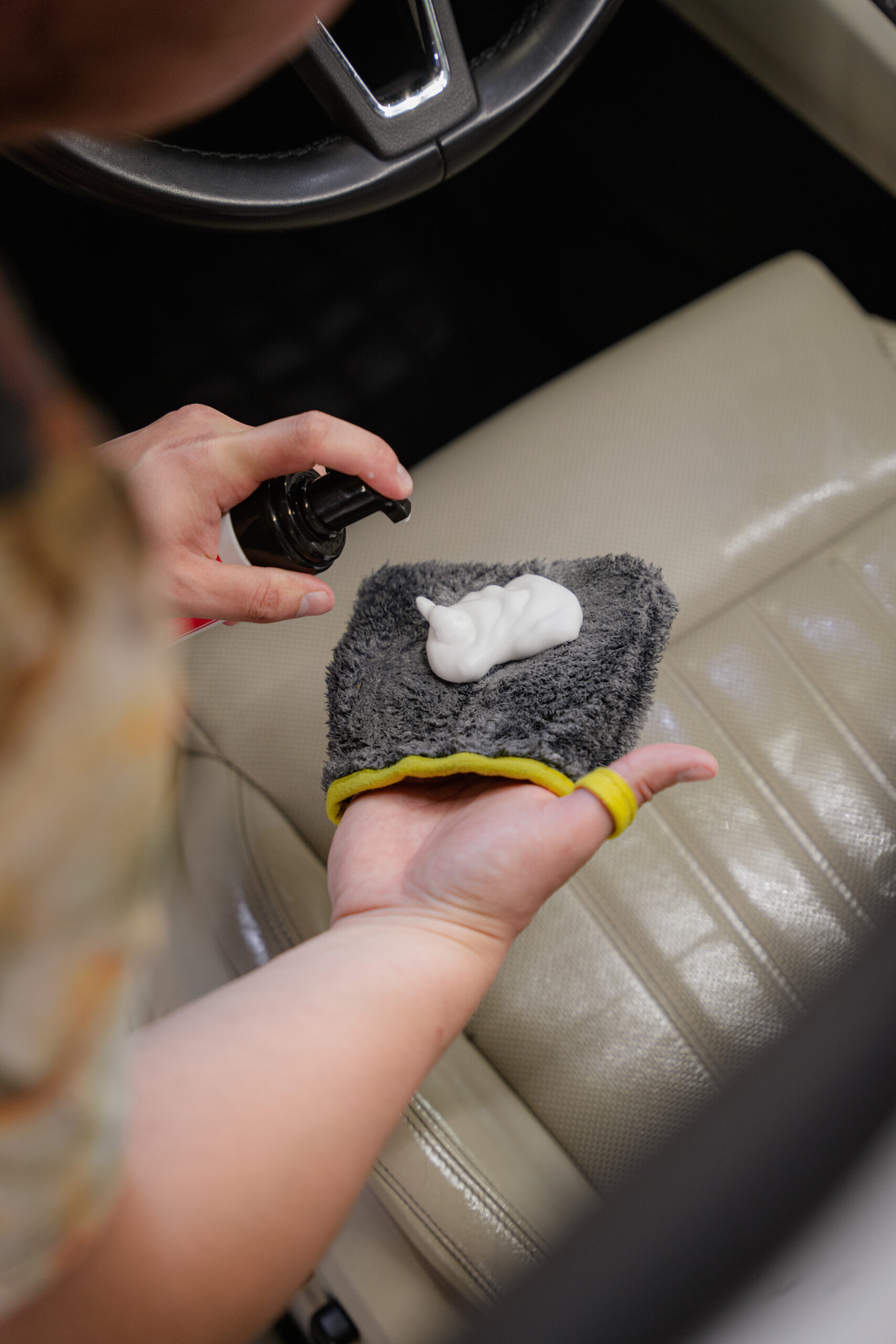 Cleaning a leather car seat with detailing tools